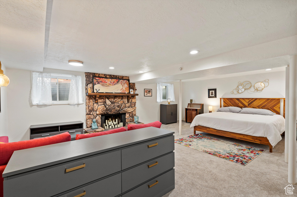 Bedroom featuring a fireplace, light colored carpet, and recessed lighting
