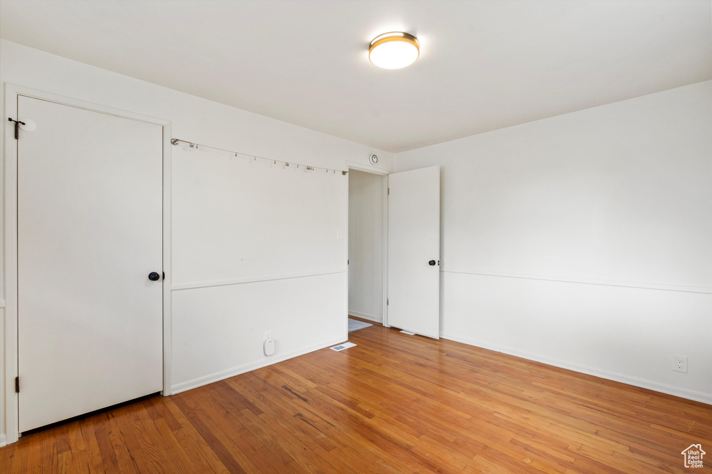 Unfurnished bedroom with light wood finished floors and baseboards