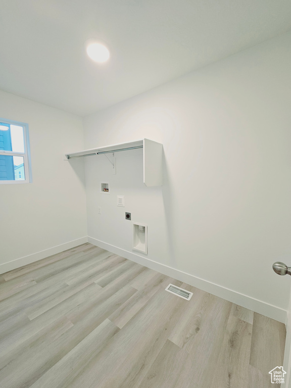 Laundry room featuring baseboards, hookup for a washing machine, light wood finished floors, and hookup for an electric dryer