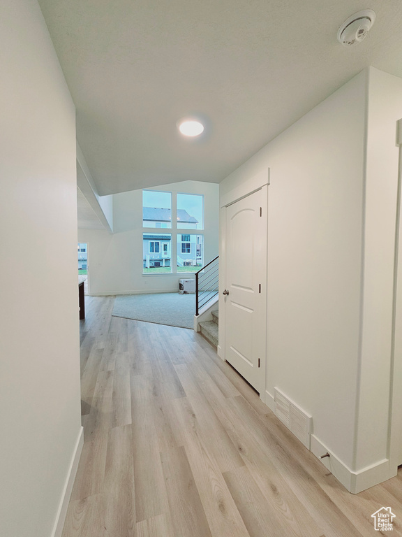 Hall featuring stairs, light wood-style floors, and baseboards