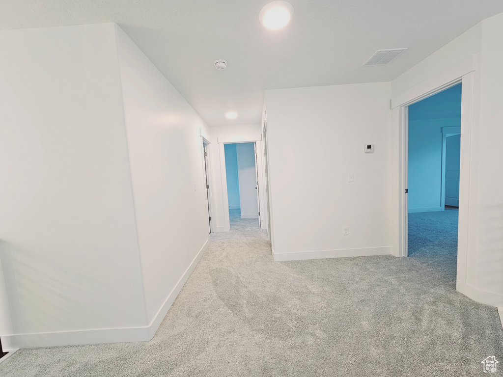 Corridor featuring carpet floors and baseboards