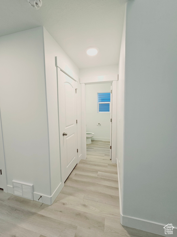 Hall with baseboards and light wood-style floors