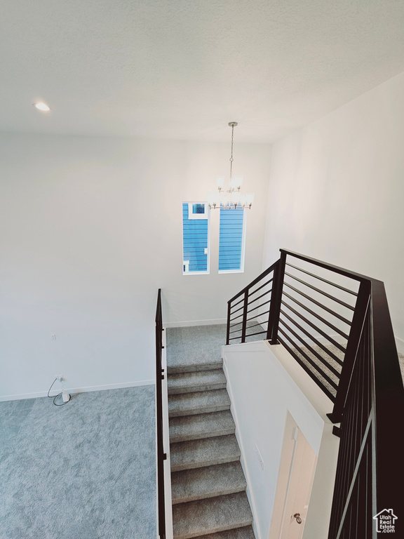 Stairway featuring carpet floors, a chandelier, baseboards, and recessed lighting