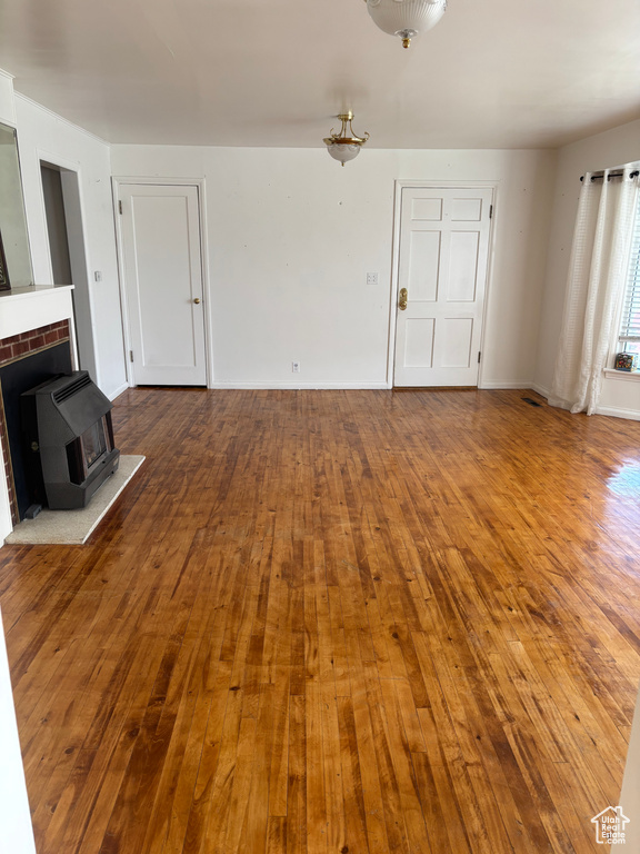 Unfurnished living room with hardwood / wood-style flooring and baseboards