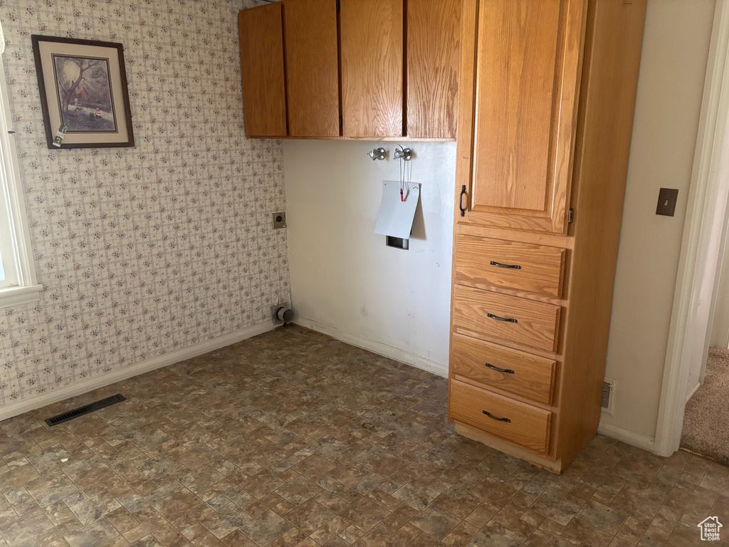 Laundry room with cabinet space and baseboards
