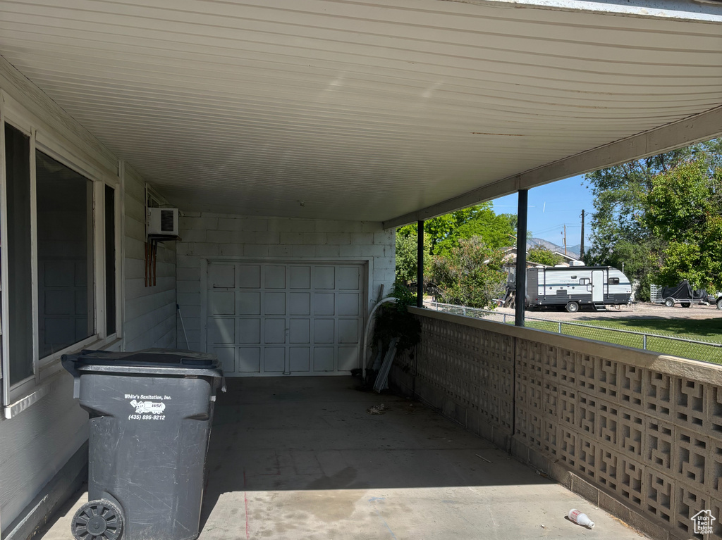 View of car parking with driveway and a wall mounted AC