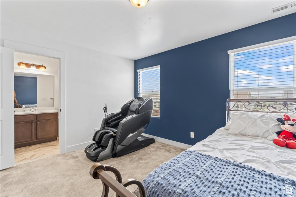 Bedroom with connected bathroom, baseboards, and light colored carpet