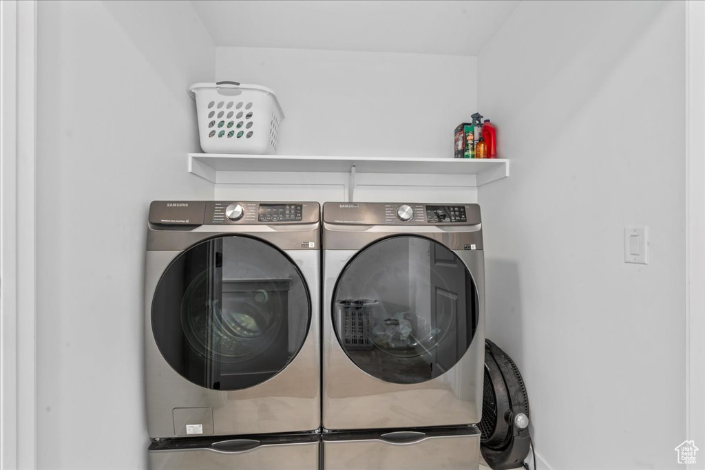Washroom featuring washing machine and clothes dryer and baseboards