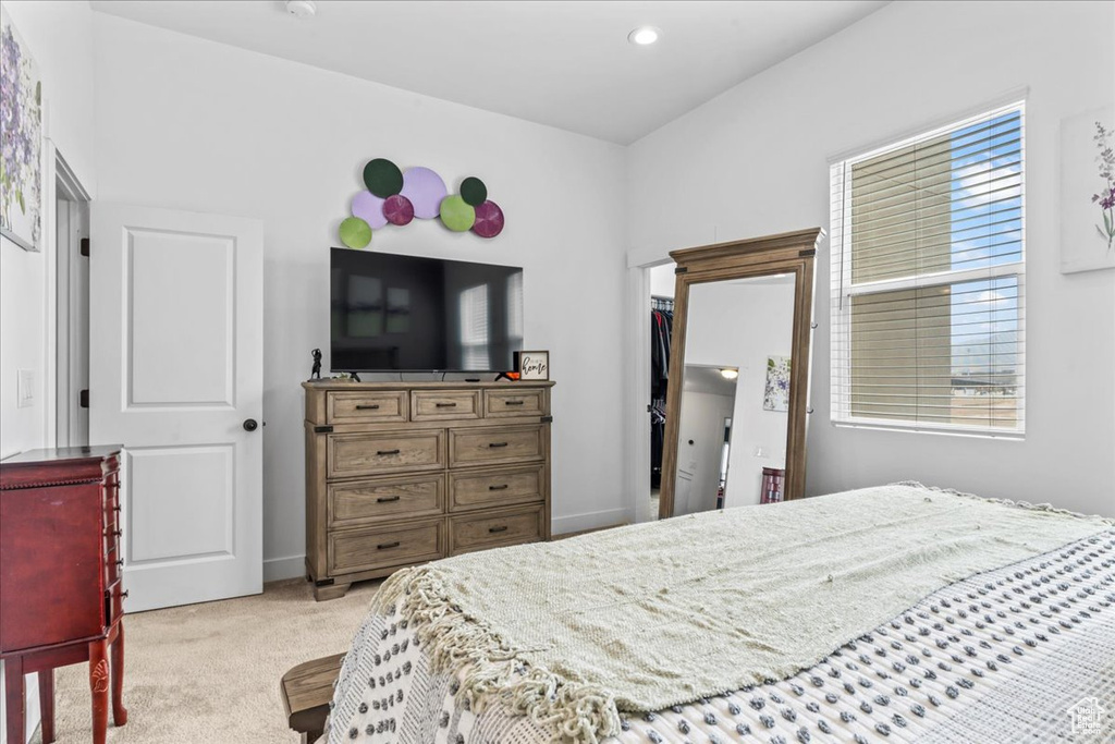 Bedroom featuring light carpet and baseboards