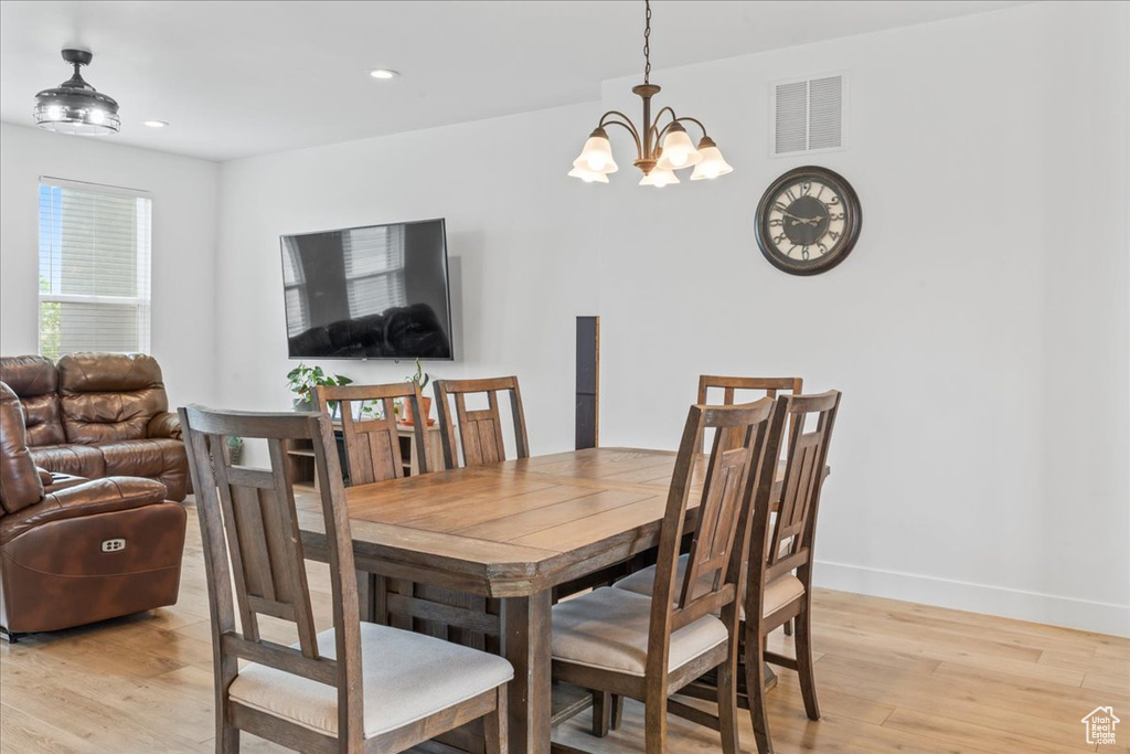 Dining space featuring light wood finished floors, a chandelier, baseboards, and recessed lighting