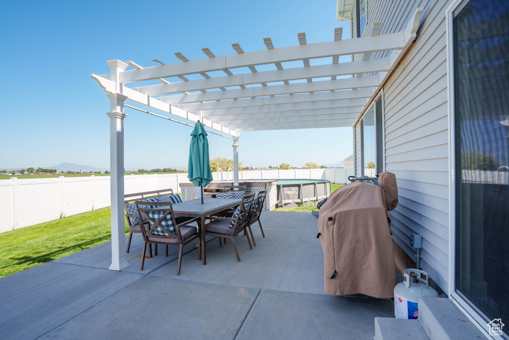 Fenced backyard featuring a patio, a pergola, outdoor dining space, and a mountain view