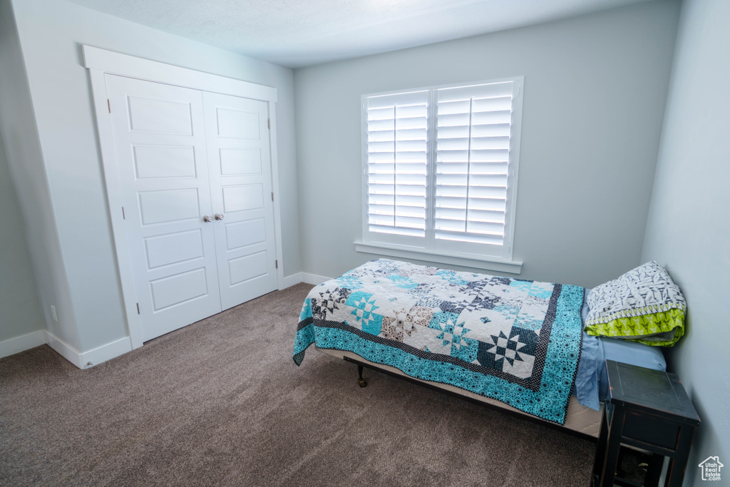 Bedroom with carpet, a closet, and baseboards