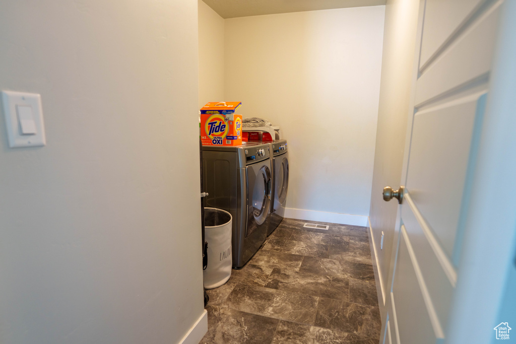 Washroom featuring washing machine and clothes dryer and baseboards