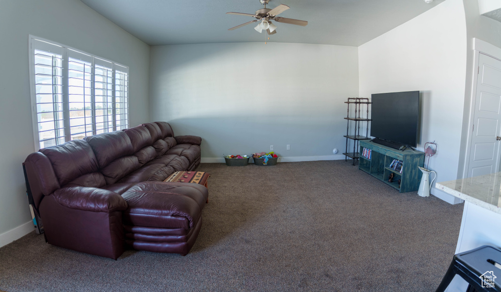 Living room with ceiling fan, carpet, and baseboards