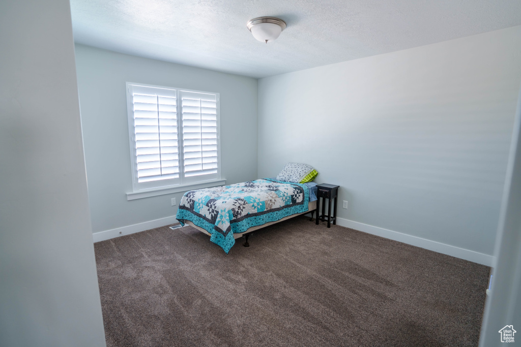 Bedroom featuring baseboards and carpet