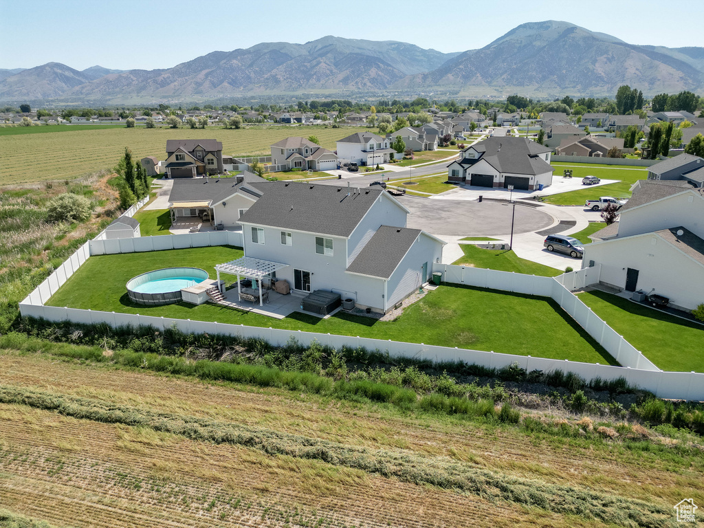 Aerial view of residential area with a pool area and a mountainous background