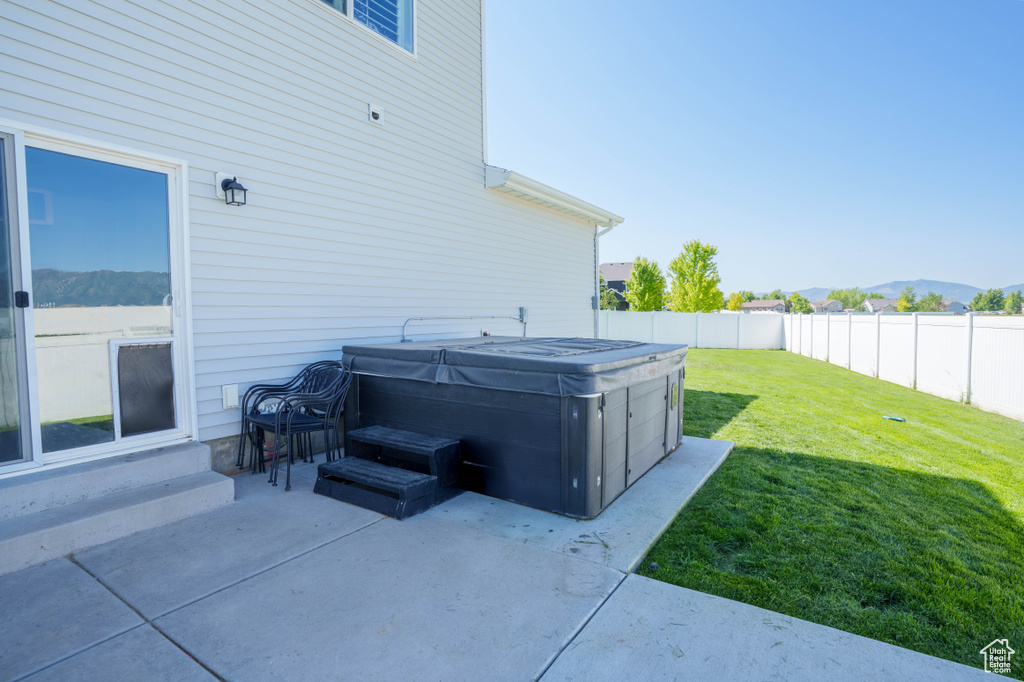 View of patio / terrace featuring a hot tub and a mountain view