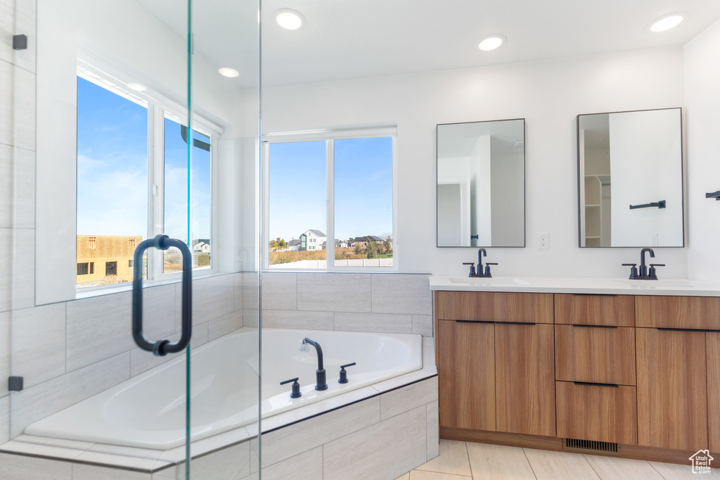 Full bathroom featuring a garden tub, double vanity, recessed lighting, a shower with door, and tile patterned flooring