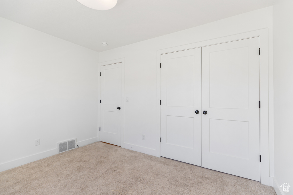 Unfurnished bedroom featuring carpet floors and baseboards