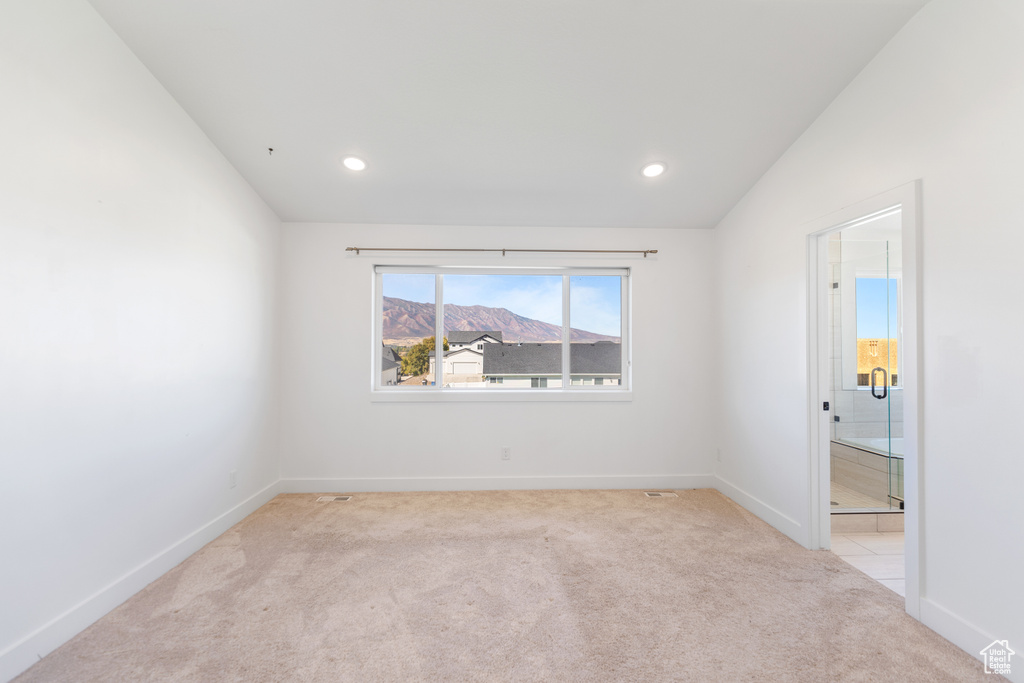 Unfurnished room with light colored carpet, baseboards, recessed lighting, and a mountain view