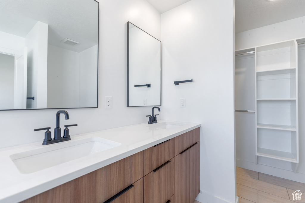 Full bathroom with double vanity and baseboards