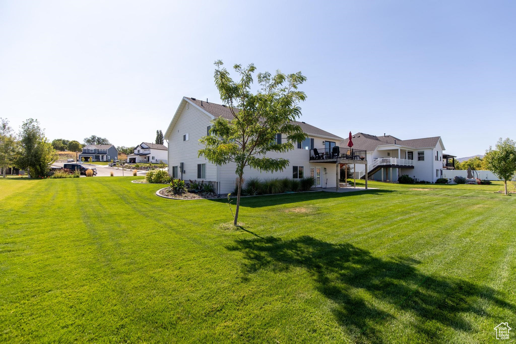 View of grassy yard with a residential view and a wooden deck
