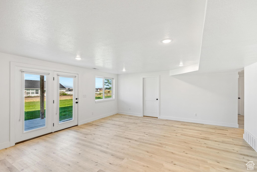 Empty room featuring light wood-type flooring, baseboards, and recessed lighting