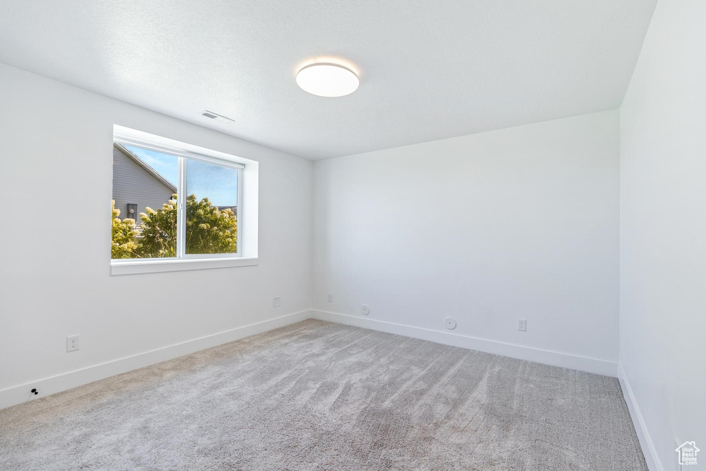 Empty room featuring baseboards and carpet