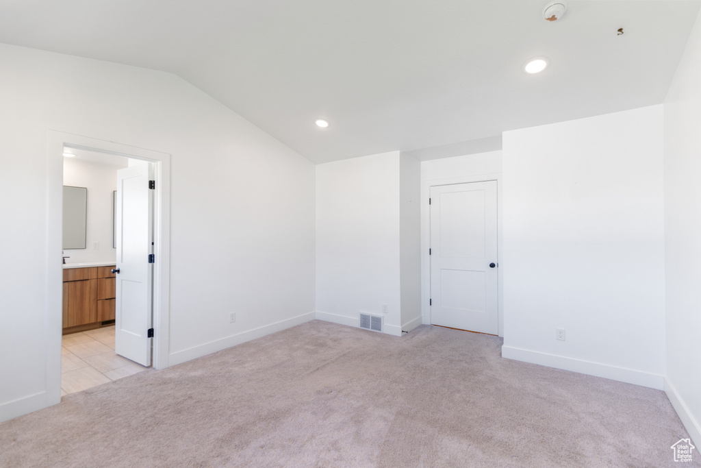 Spare room with light colored carpet, lofted ceiling, baseboards, recessed lighting, and a smoke detector