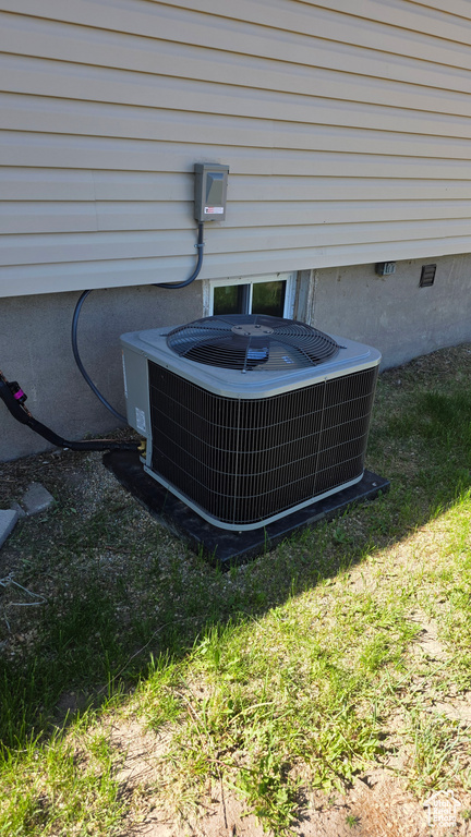 Exterior view of central AC unit and crawl space