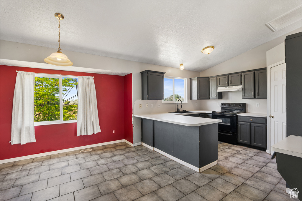 Kitchen with black / electric stove, under cabinet range hood, light countertops, a peninsula, and a textured ceiling