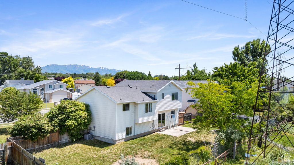 Rear view of property with a patio, a mountain view, a residential view, cooling unit, and roof with shingles