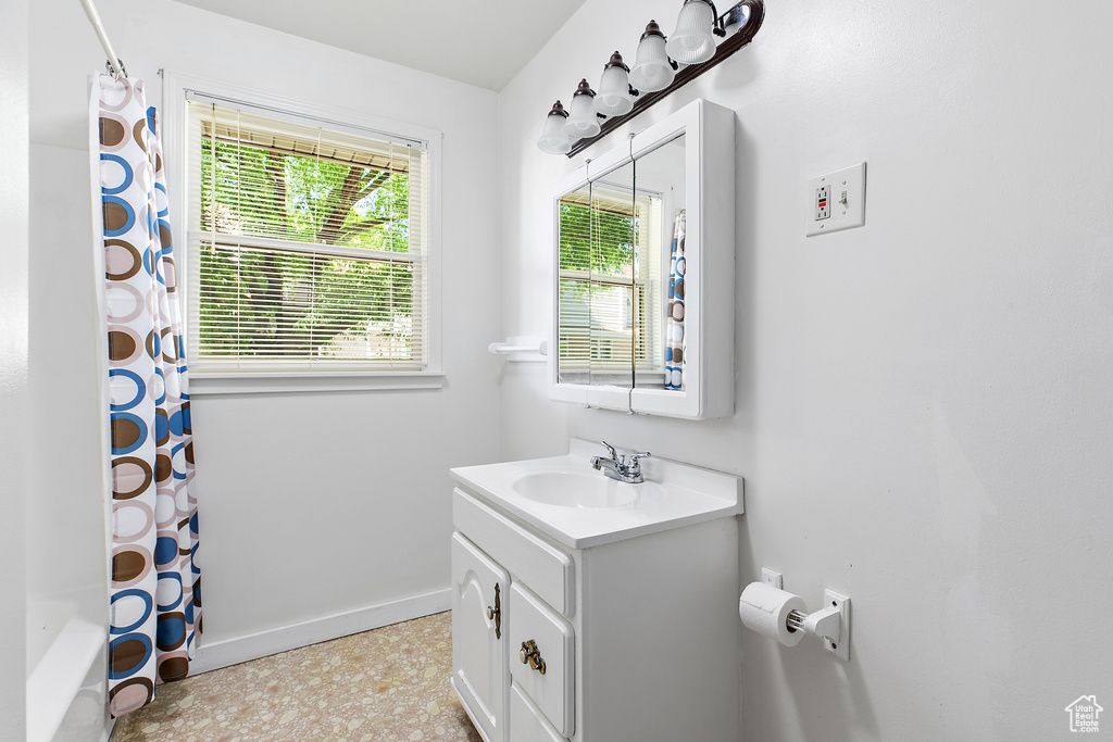 Full bathroom featuring vanity, baseboards, and shower / bath combo with shower curtain