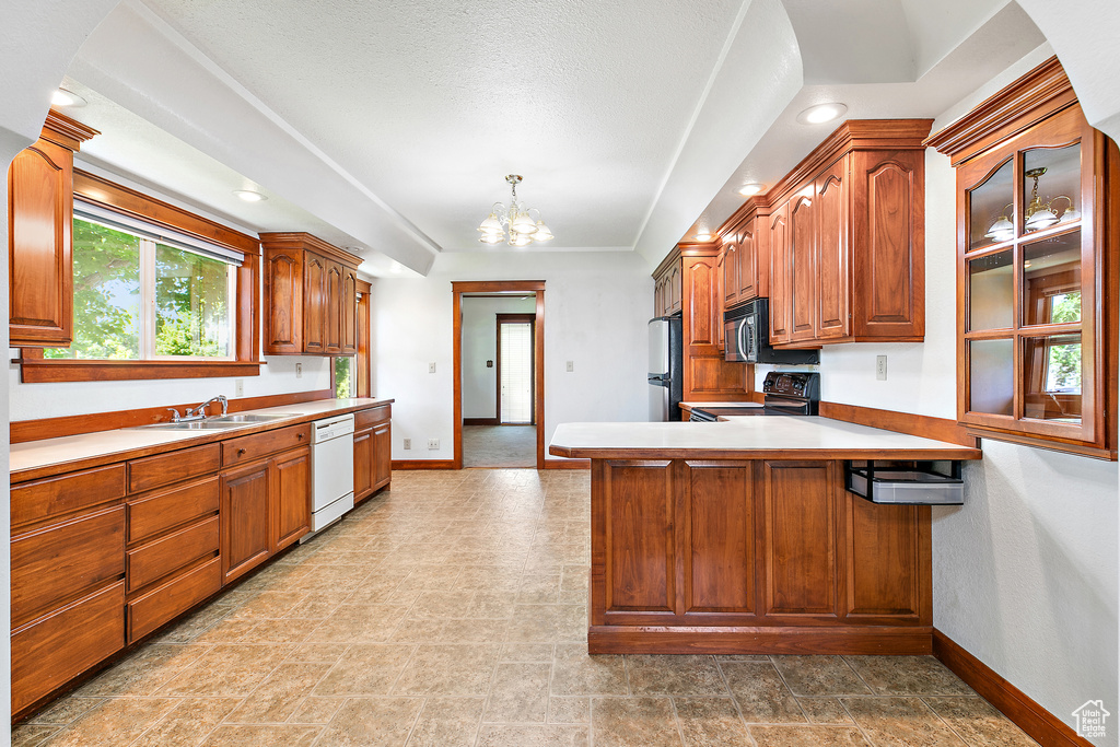 Kitchen featuring baseboards, freestanding refrigerator, range, white dishwasher, and a sink