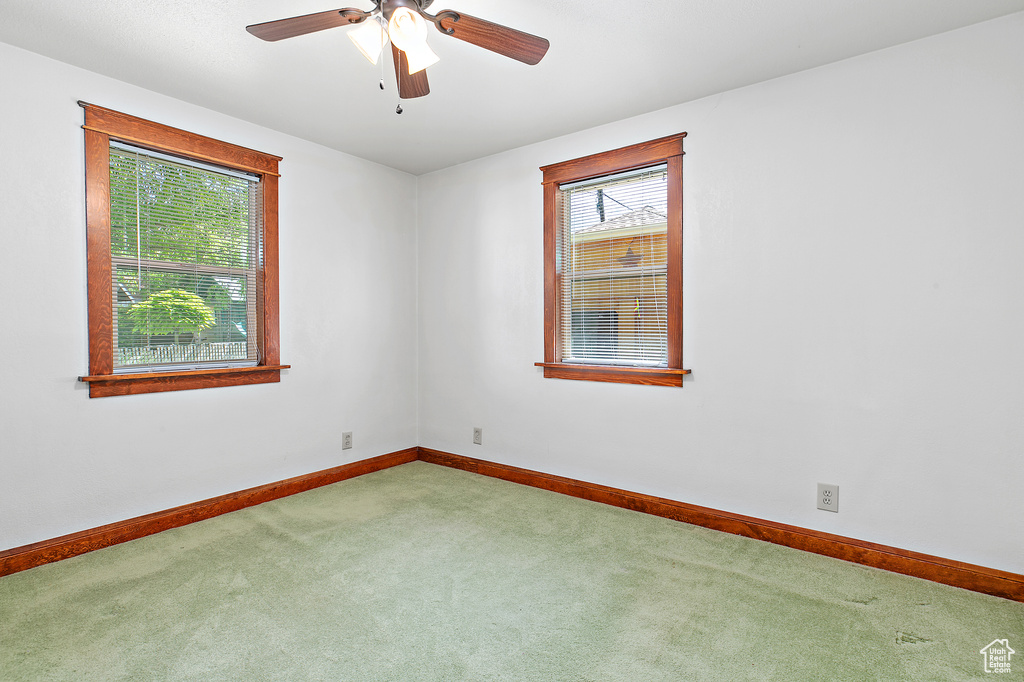 Carpeted empty room with baseboards and ceiling fan