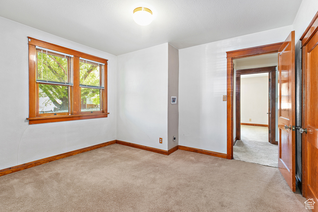 Empty room with light carpet and baseboards
