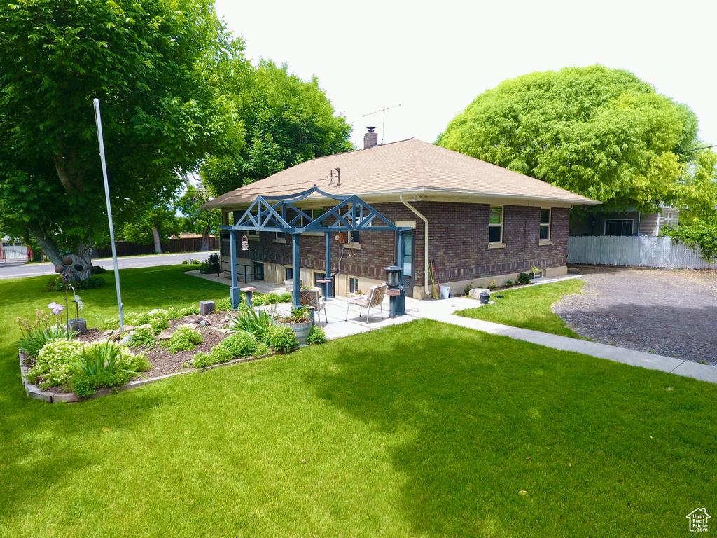 Back of property with a chimney, brick siding, and a patio area