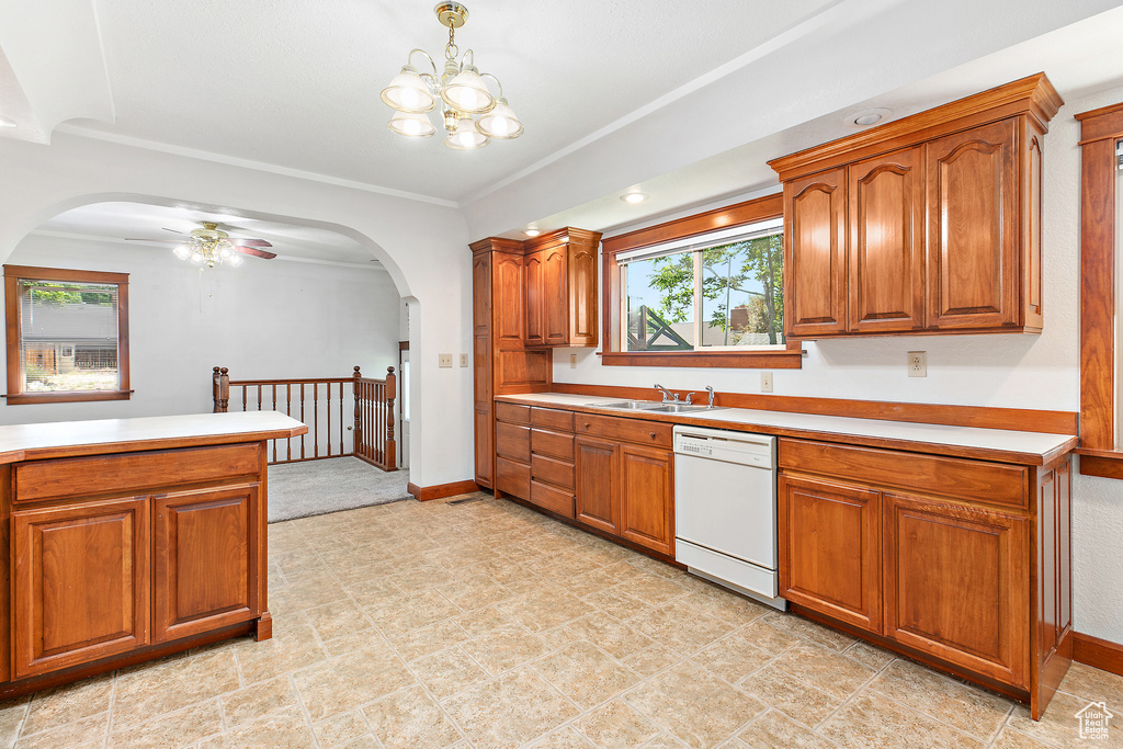 Kitchen with white dishwasher, arched walkways, brown cabinetry, and ornamental molding