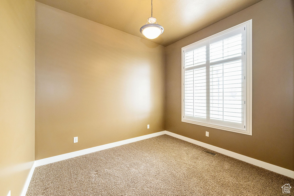 Empty room featuring healthy amount of natural light, carpet, and baseboards