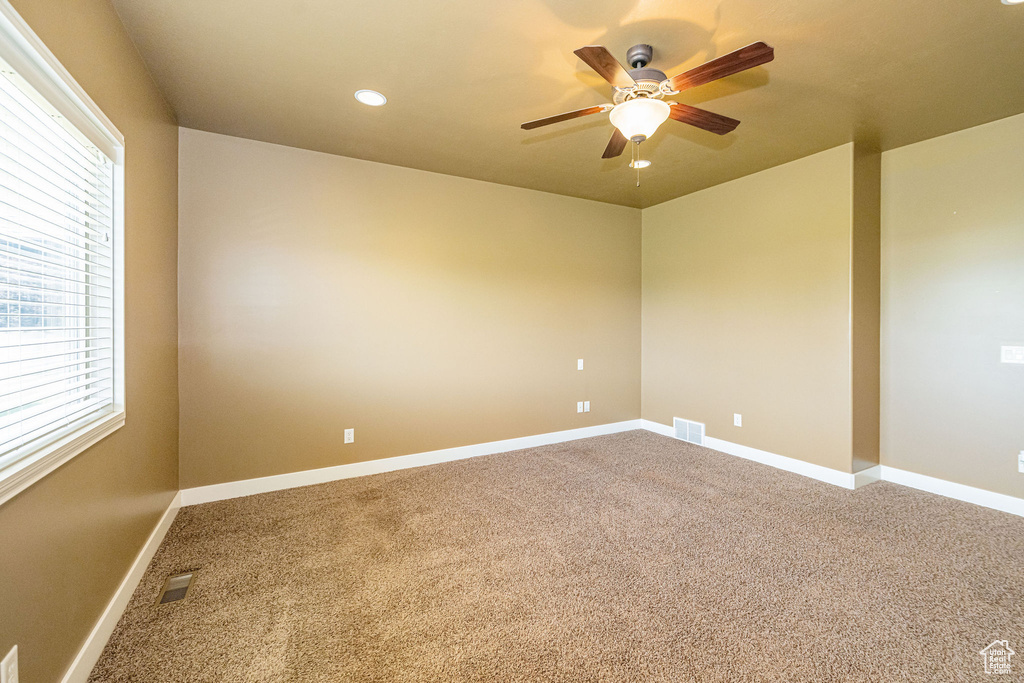 Spare room with a ceiling fan, healthy amount of natural light, carpet flooring, and recessed lighting