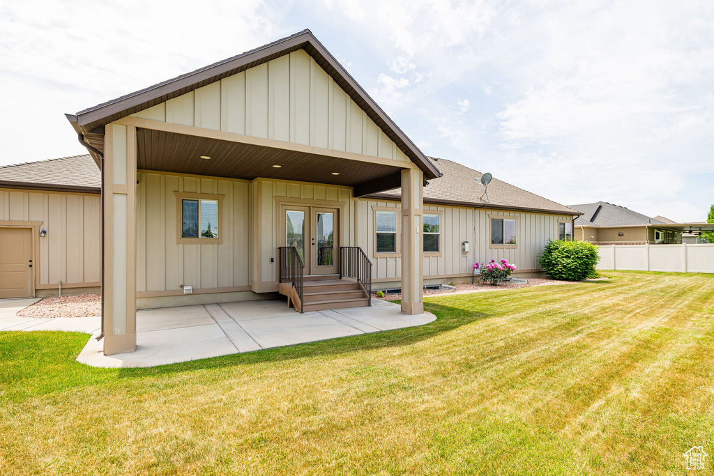 Back of house with board and batten siding, french doors, a patio, and roof with shingles