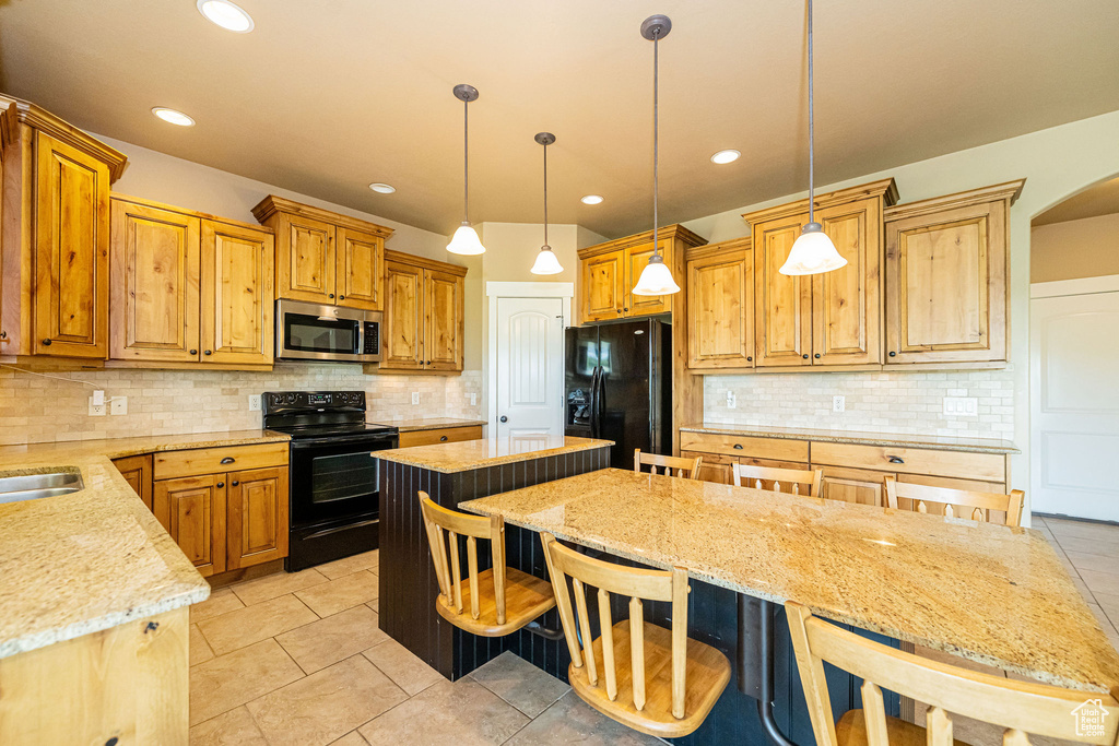 Kitchen with black appliances, backsplash, light tile patterned floors, and recessed lighting
