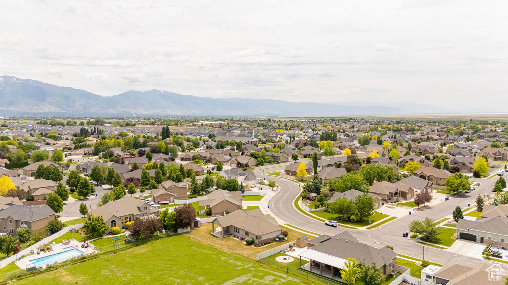 Aerial view of residential area featuring mountains and a pool