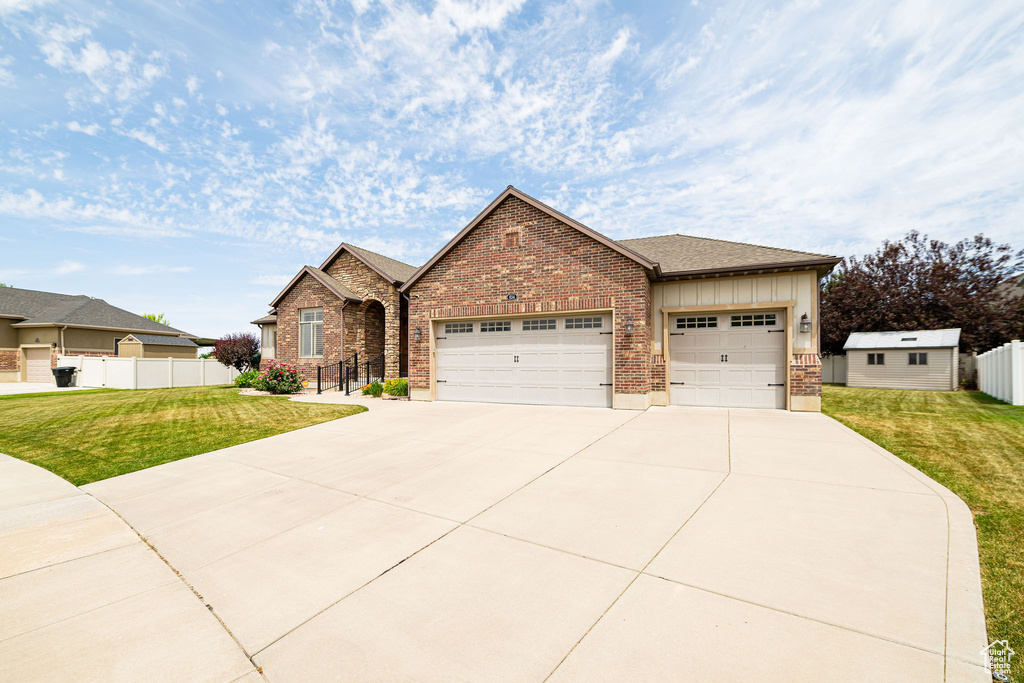 View of front facade with board and batten siding, concrete driveway, a garage, and brick siding