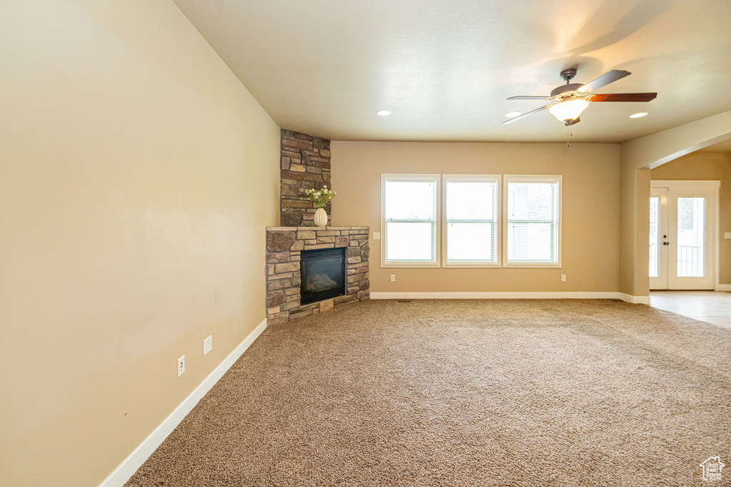 Unfurnished living room with baseboards, a ceiling fan, a fireplace, carpet floors, and recessed lighting