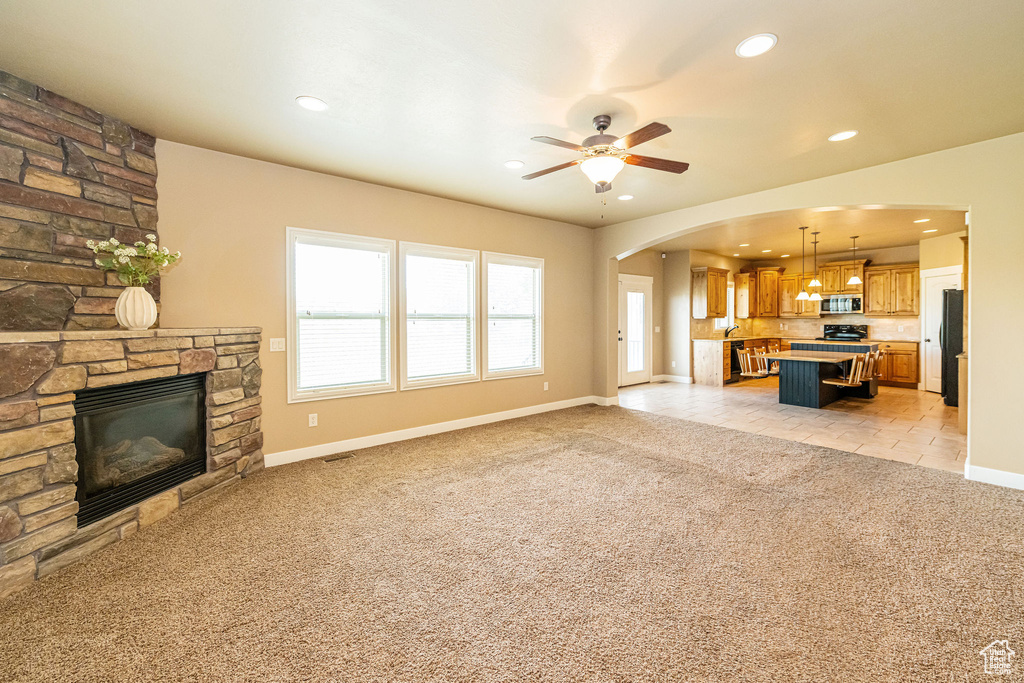 Unfurnished living room featuring light carpet, recessed lighting, a fireplace, ceiling fan, and baseboards