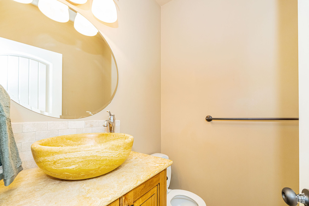 Bathroom with tasteful backsplash, toilet, and vanity