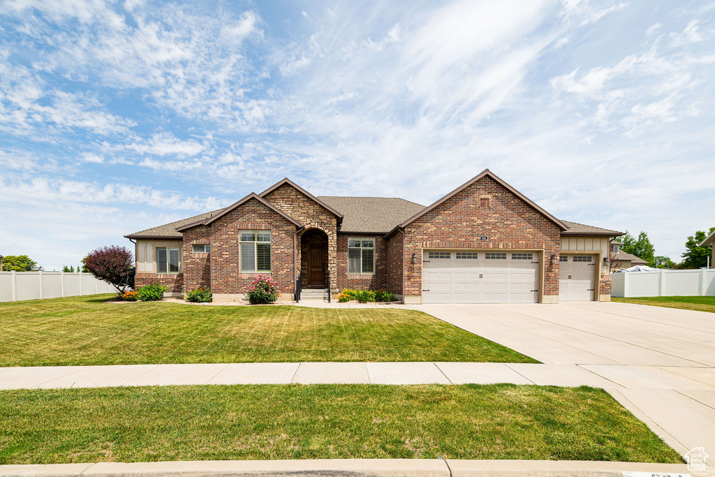View of front facade with brick siding, a garage, concrete driveway, and roof with shingles