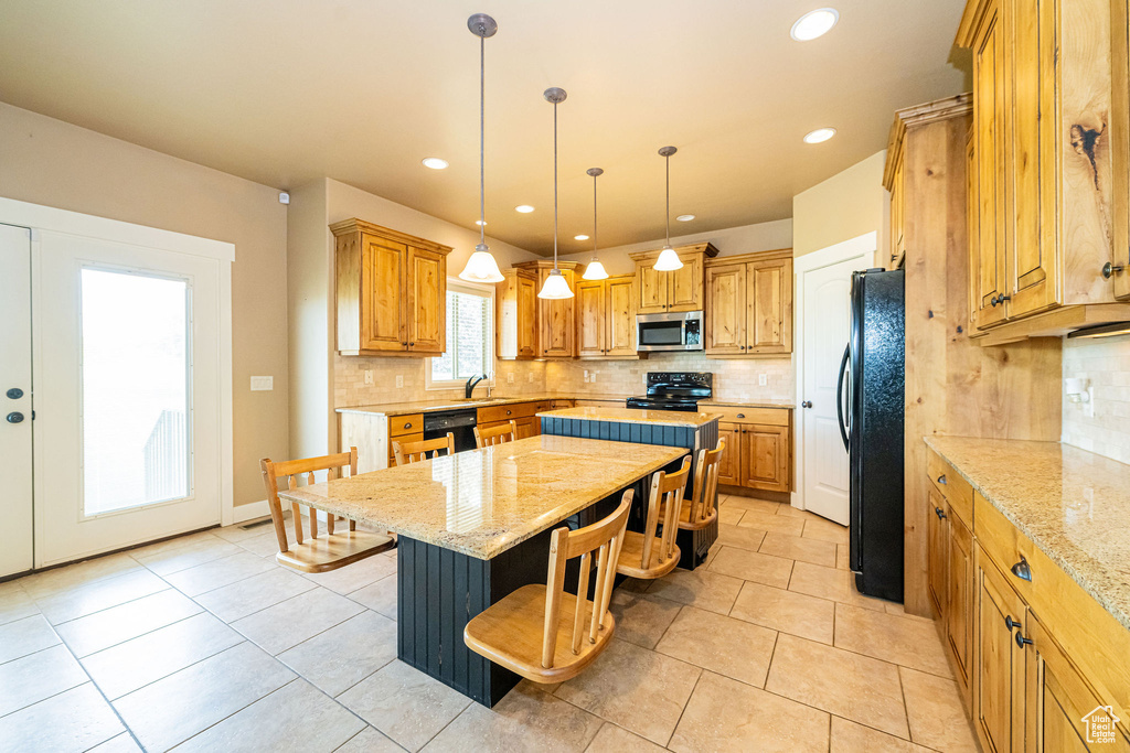 Kitchen featuring black appliances, a sink, a center island, backsplash, and recessed lighting