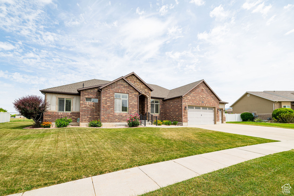 View of front facade with brick siding, concrete driveway, an attached garage, and a shingled roof